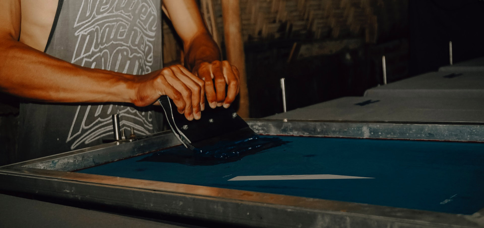 Ink being pushed through a screen to create a screen print
